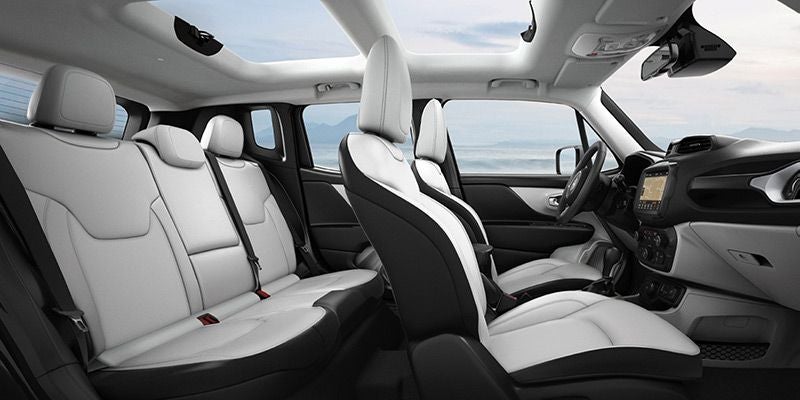 Car interior with white and black two-tone seats, a large sunroof, and the dashboard on the right.